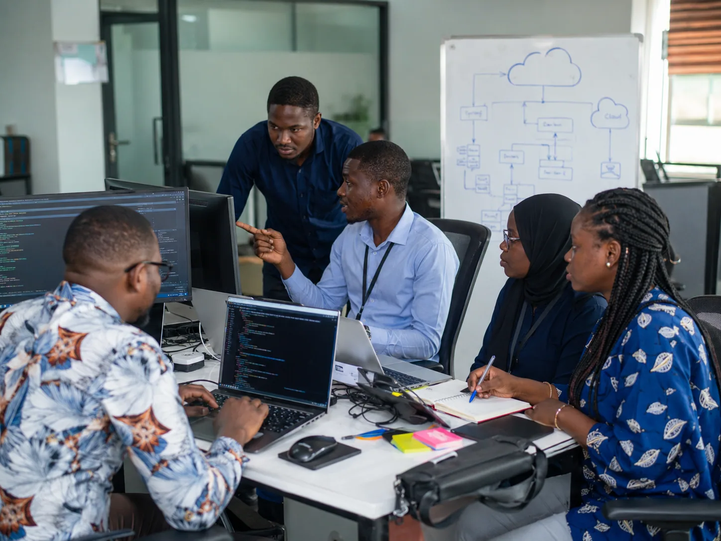 Information technology professionals collaborating around computers